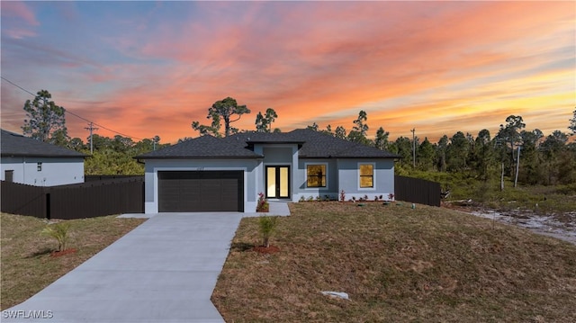 view of front of house featuring a front yard, fence, an attached garage, stucco siding, and concrete driveway