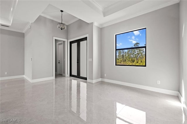 empty room with a tray ceiling, an inviting chandelier, crown molding, and baseboards