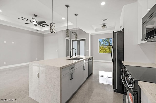 kitchen featuring visible vents, a kitchen island with sink, a sink, black appliances, and a raised ceiling