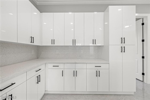 kitchen with light stone counters, tasteful backsplash, modern cabinets, and white cabinetry