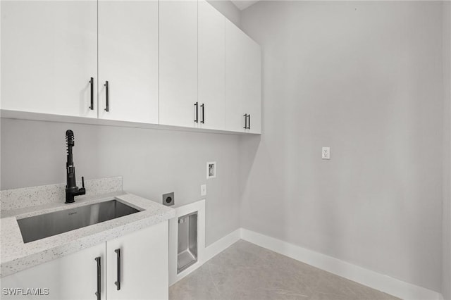 laundry area featuring hookup for a washing machine, baseboards, hookup for an electric dryer, cabinet space, and a sink