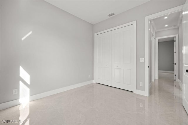 unfurnished bedroom with marble finish floor, baseboards, visible vents, and a closet