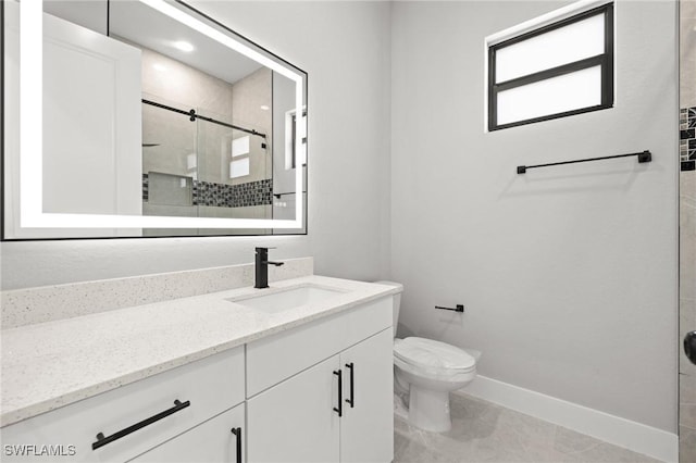 full bathroom with vanity, a shower stall, toilet, and baseboards