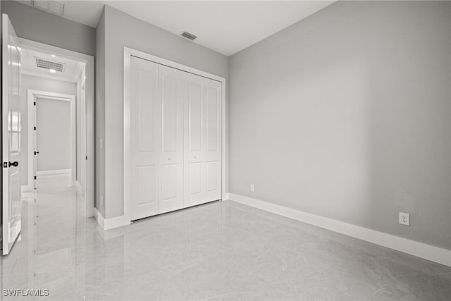 unfurnished bedroom with a closet, visible vents, and baseboards