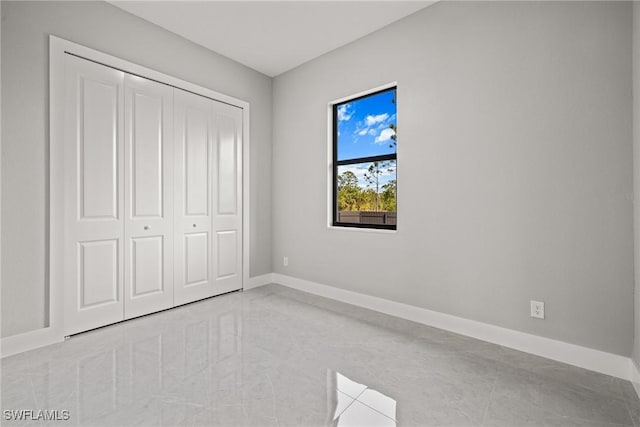 unfurnished bedroom featuring a closet and baseboards