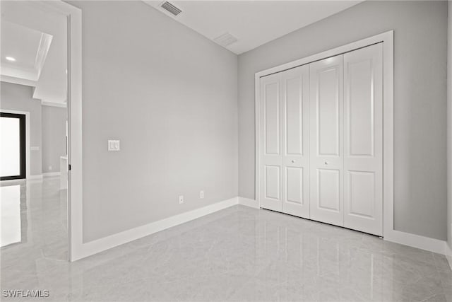 unfurnished bedroom with marble finish floor, baseboards, visible vents, and a closet