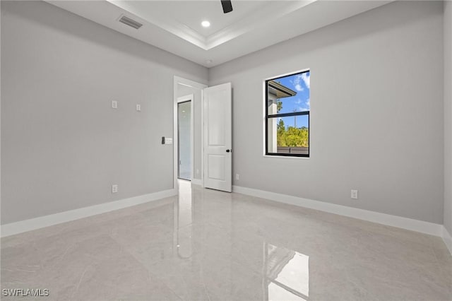 spare room with visible vents, marble finish floor, a tray ceiling, recessed lighting, and baseboards