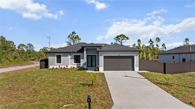 view of front of property featuring a front lawn, fence, stucco siding, a garage, and driveway