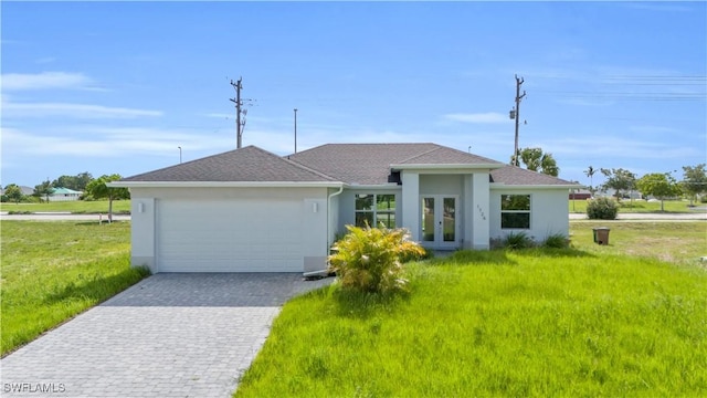 view of front of home featuring stucco siding, french doors, an attached garage, and decorative driveway