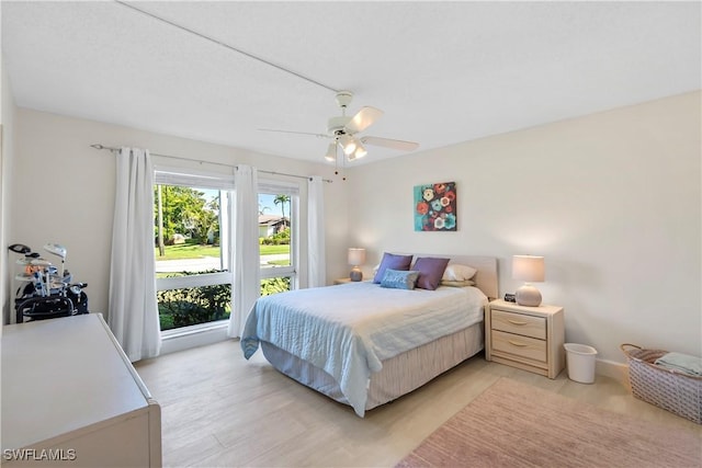 bedroom with baseboards, a ceiling fan, and light wood finished floors