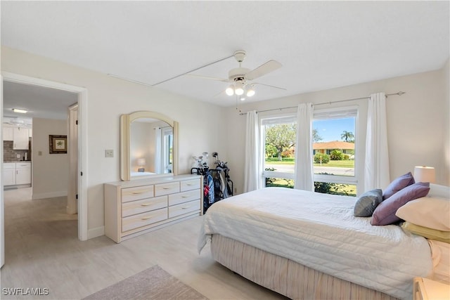 bedroom with a ceiling fan, light wood-style floors, and baseboards