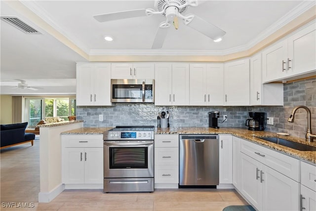 kitchen featuring visible vents, a sink, backsplash, stainless steel appliances, and white cabinets