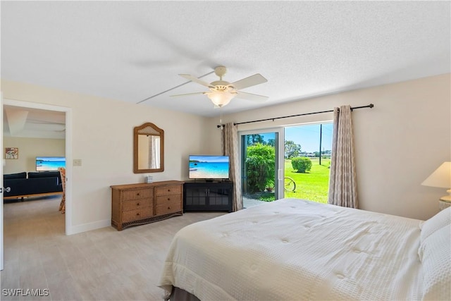 bedroom featuring light wood-style floors, baseboards, a textured ceiling, and a ceiling fan