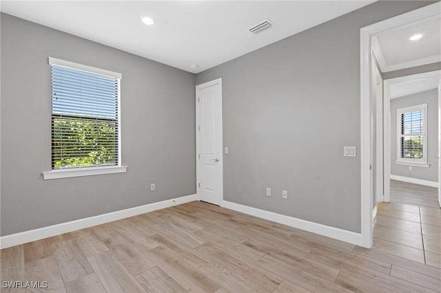 spare room featuring visible vents, recessed lighting, light wood-type flooring, and baseboards