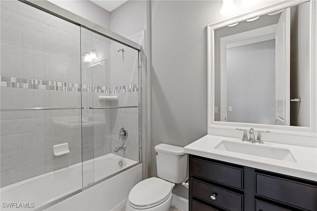 bathroom featuring toilet, vanity, and shower / bath combination with glass door