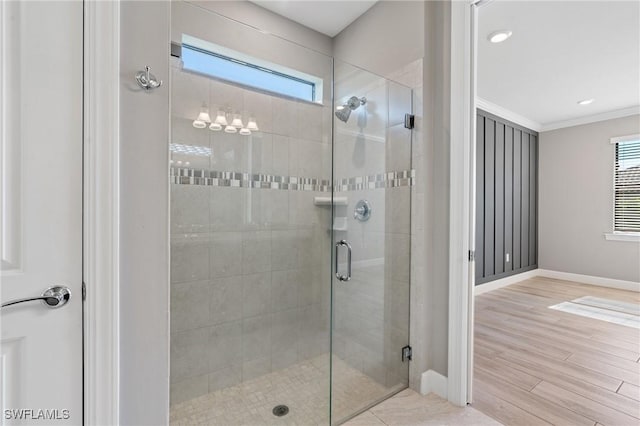 full bath featuring baseboards, wood finished floors, a shower stall, and crown molding