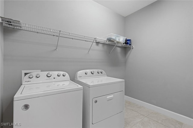 clothes washing area featuring laundry area, light tile patterned floors, baseboards, and independent washer and dryer