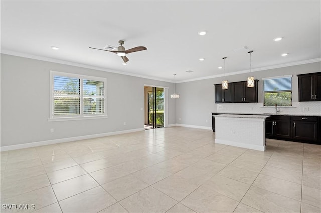 kitchen featuring a sink, open floor plan, and crown molding