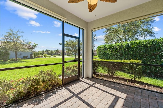 unfurnished sunroom with a wealth of natural light and ceiling fan