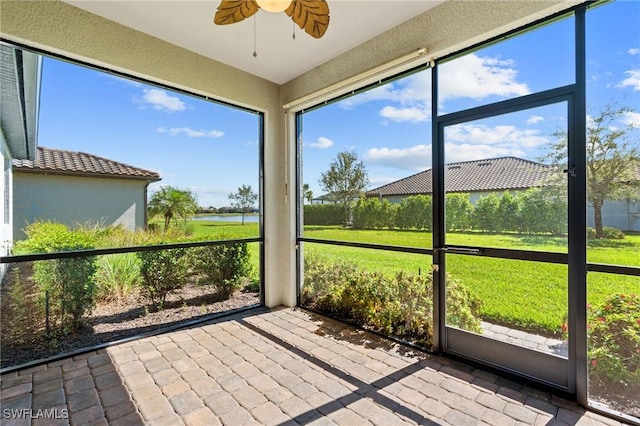 unfurnished sunroom featuring a ceiling fan