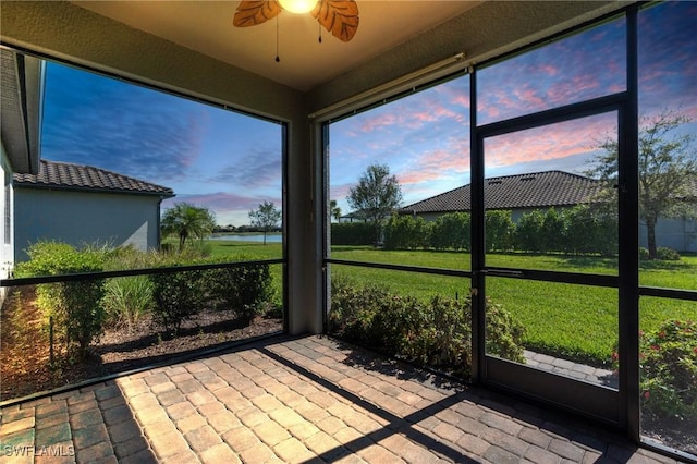 unfurnished sunroom with a ceiling fan