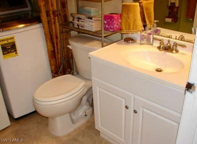 bathroom featuring vanity, toilet, and tile patterned flooring