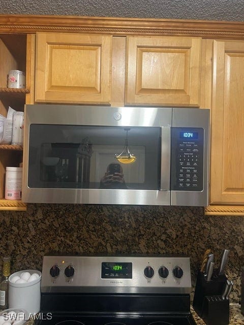 room details featuring decorative backsplash, dark countertops, appliances with stainless steel finishes, and light brown cabinetry