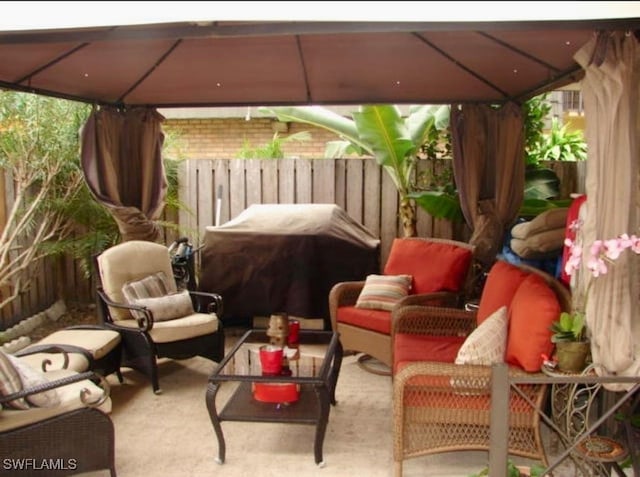 view of patio featuring a gazebo, fence, and an outdoor hangout area