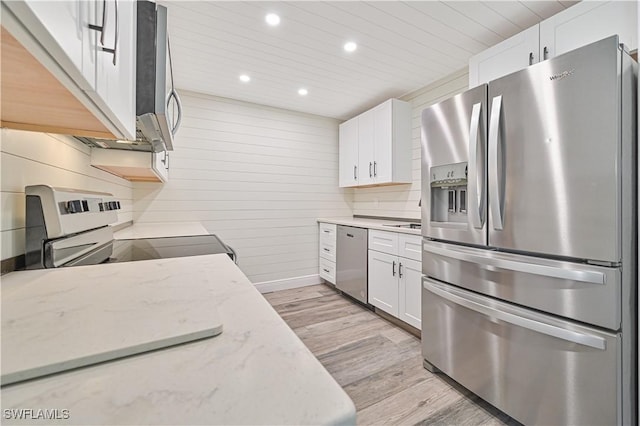 kitchen with stainless steel appliances, light stone countertops, light wood-style floors, and white cabinets