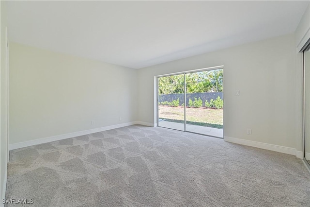 unfurnished room featuring baseboards and light colored carpet