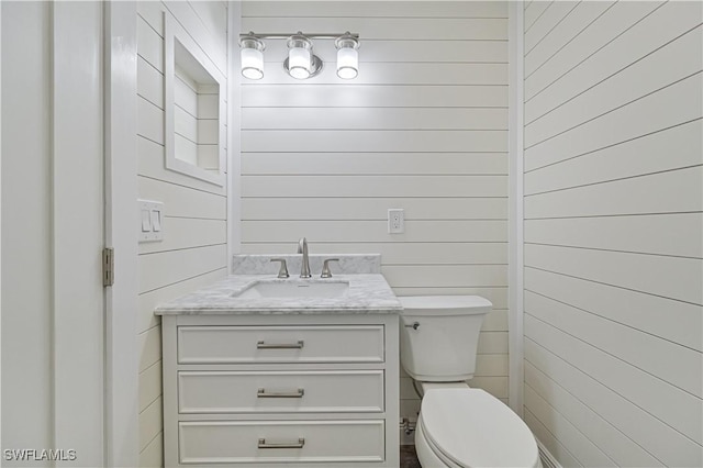 half bathroom with toilet and vanity