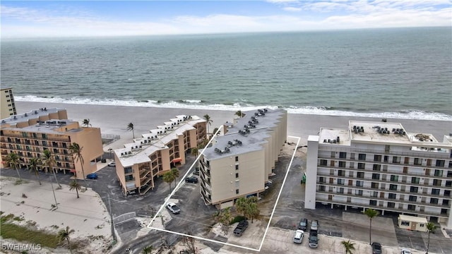 drone / aerial view featuring a beach view and a water view