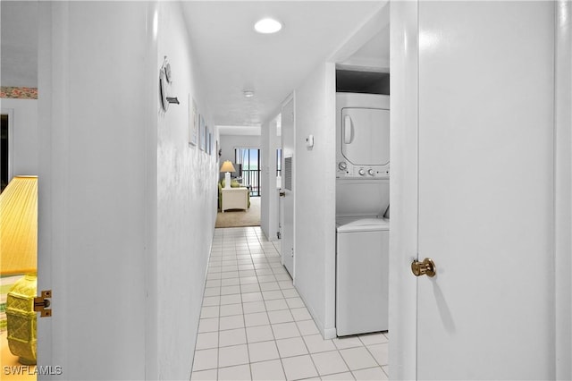 hallway featuring light tile patterned floors and stacked washer / drying machine