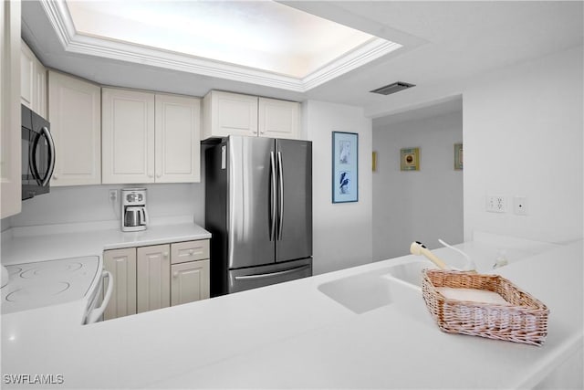 kitchen with visible vents, freestanding refrigerator, a sink, light countertops, and black microwave