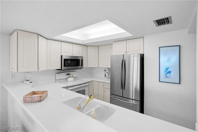 kitchen with visible vents, a sink, stainless steel appliances, light countertops, and white cabinetry