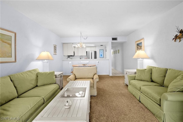 living room featuring a chandelier, visible vents, and light colored carpet