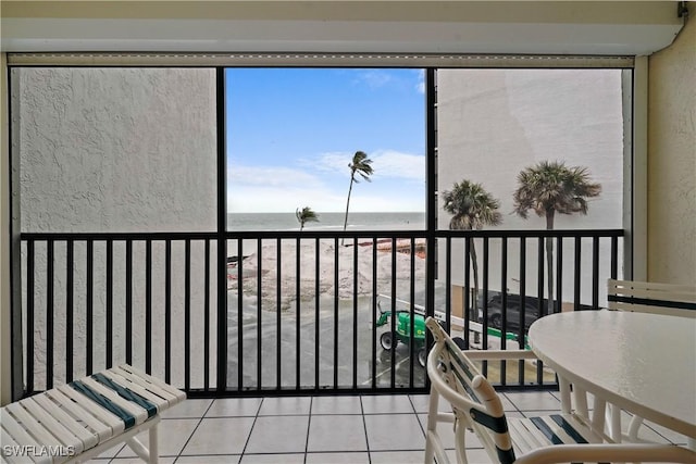 balcony featuring a beach view and a water view