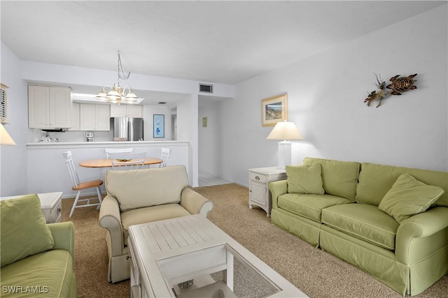 living room featuring a notable chandelier, visible vents, and carpet flooring