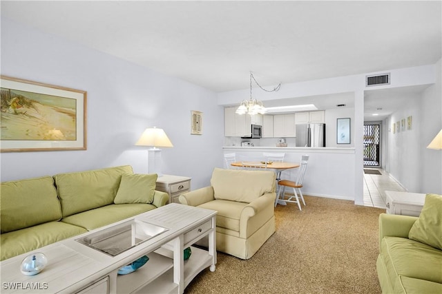 living area with a notable chandelier, light colored carpet, and visible vents