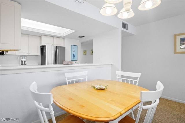 dining room with carpet flooring, baseboards, and visible vents