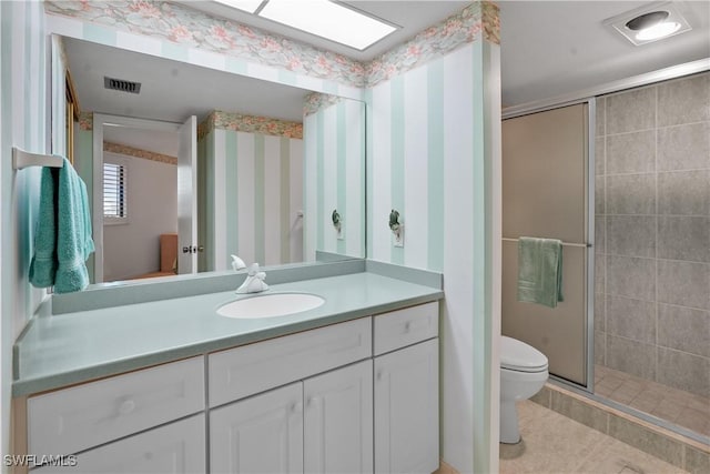 bathroom featuring vanity, visible vents, wallpapered walls, a shower stall, and toilet