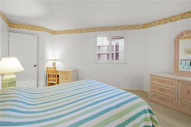 bedroom with baseboards and light carpet