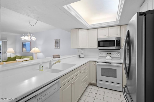 kitchen featuring light countertops, appliances with stainless steel finishes, light tile patterned flooring, a raised ceiling, and a sink