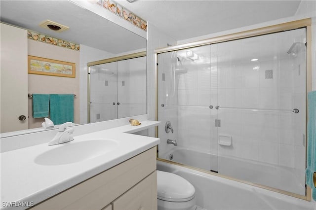 bathroom featuring visible vents, enclosed tub / shower combo, toilet, and vanity