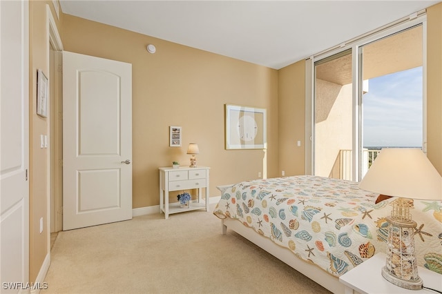 bedroom with a wall of windows, baseboards, carpet, and access to exterior