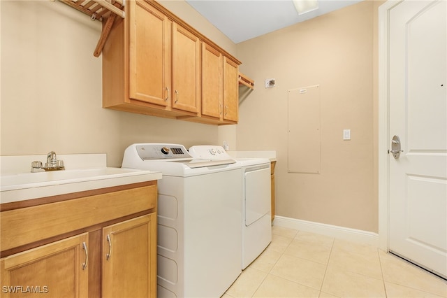 washroom with light tile patterned flooring, cabinet space, washer and dryer, and baseboards