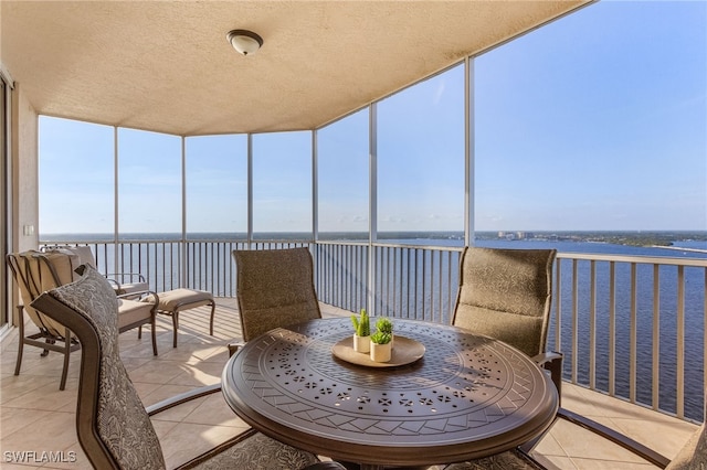 sunroom featuring a water view