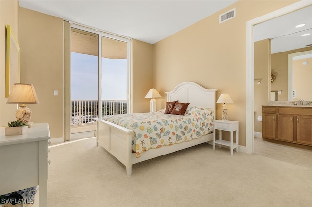 bedroom with access to exterior, visible vents, baseboards, light colored carpet, and a sink