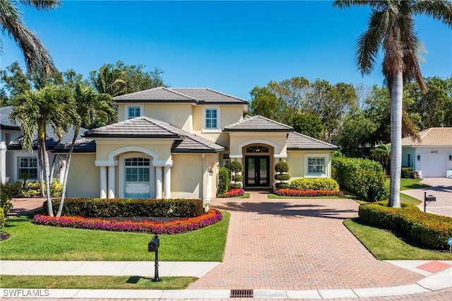 6849 Il Regalo Cir, Naples, FL 34109 - mediterranean / spanish-style house with stucco siding, decorative driveway, french doors, a front yard, and a tiled roof