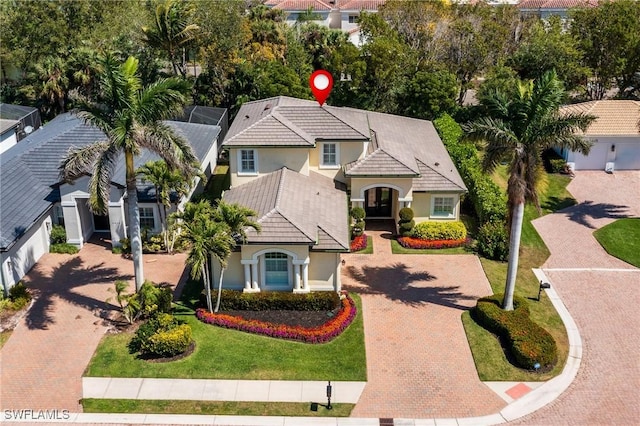 6849 Il Regalo Cir, Naples, FL 34109 - mediterranean / spanish-style house with decorative driveway, a lanai, a front yard, and stucco siding